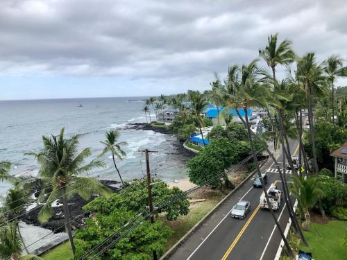a road next to the ocean with palm trees at AMAZING OCEAN VIEW - Kona Alii Condo KA606 in Kailua-Kona
