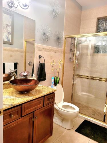 a bathroom with a sink and a toilet and a shower at Cape Paradise B & B - Your Luxury Tropical Retreat in Cape Coral