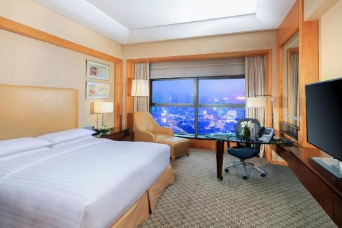 a hotel room with a bed and a desk and a window at Ningbo Marriott Hotel in Ningbo