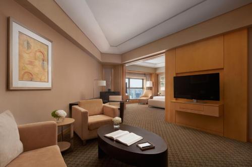 a hotel room with a living room with a television at Ningbo Marriott Hotel in Ningbo