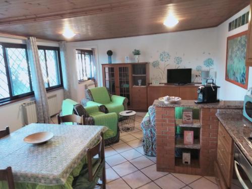 een keuken en een woonkamer met een tafel en stoelen bij ZÍ MARIO Suite degli Ospiti - Roma Ostia Antica in Ostia Antica