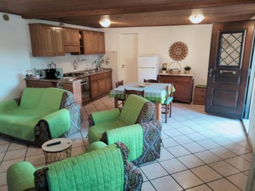 sala de estar con sillas verdes y cocina en ZÍ MARIO Suite degli Ospiti - Roma Ostia Antica, en Ostia Antica
