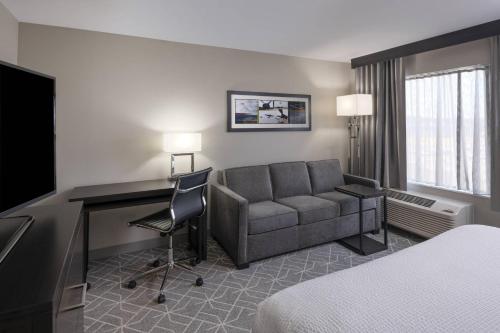 een hotelkamer met een bank en een bureau bij TownePlace Suites by Marriott Providence North Kingstown in North Kingstown