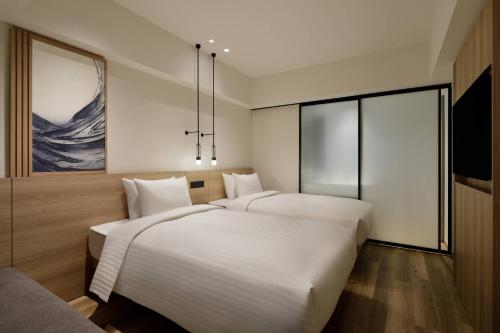 a hotel room with two beds and a television at Fairfield by Marriott Osaka Namba in Osaka