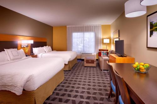 a hotel room with two beds and a television at TownePlace Suites by Marriott Missoula in Missoula