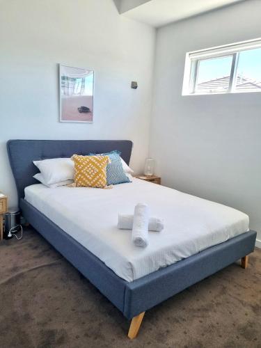 a bedroom with a large bed with two towels on it at Aspendale Beach Escape -Walk To Mordialloc in Aspendale