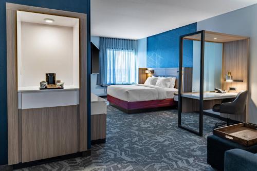 Habitación de hotel con cama y espejo en SpringHill Suites by Marriott Overland Park Leawood, en Overland Park