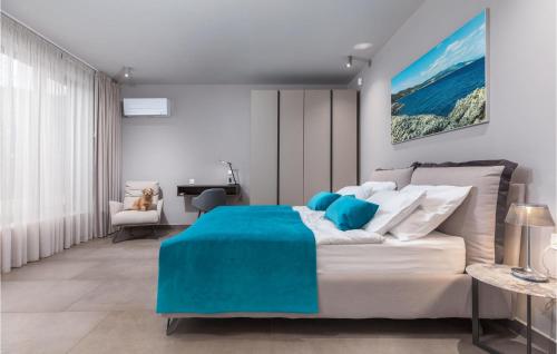 een slaapkamer met een groot bed en een blauwe deken bij Nice Home In Labin With Wifi in Labin