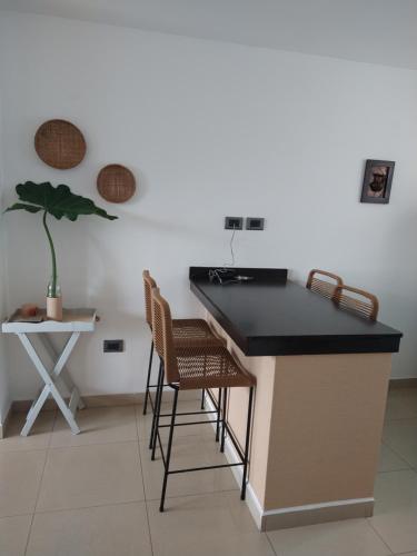 a kitchen with a counter with chairs and a table at Hermosa energía in San Salvador de Jujuy