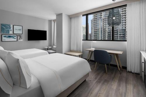 Habitación blanca con cama y escritorio en Element Miami Brickell, en Miami