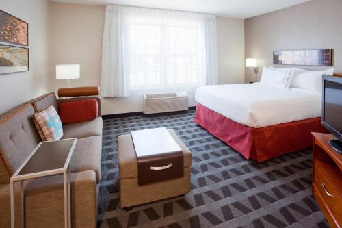 um quarto de hotel com uma cama e um sofá em TownePlace Suites Minneapolis West/St. Louis Park em Saint Louis Park