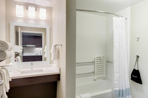 La salle de bains blanche est pourvue d'un lavabo et d'une douche. dans l'établissement TownePlace Suites by Marriott Kansas City Liberty, à Liberty