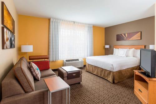 a hotel room with a bed and a television at TownePlace Suites Phoenix North in Phoenix