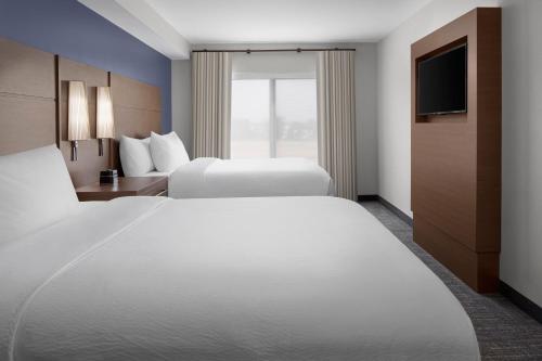 a hotel room with two beds and a television at Residence Inn by Marriott Rehoboth Beach in Rehoboth Beach