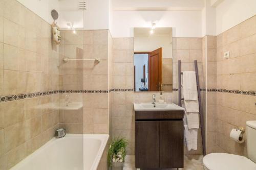y baño con bañera, lavabo y aseo. en Casa da Praia, Santa Luzia, en Tavira