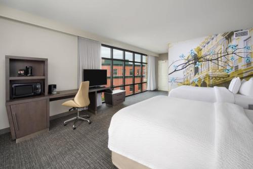 a hotel room with a bed and a desk with a computer at Courtyard by Marriott Richmond Downtown in Richmond