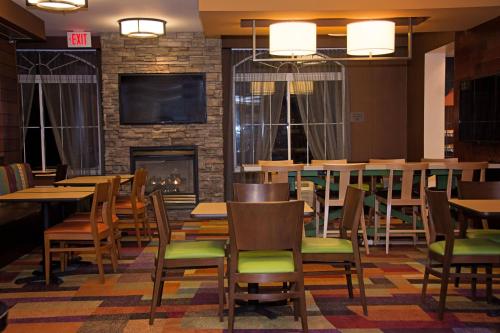 a restaurant with tables and chairs and a fireplace at Fairfield Inn & Suites Butler in Butler