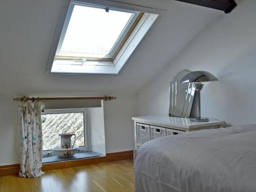 a bedroom with a bed and a large window at Holly Cottage in Ystalyfera