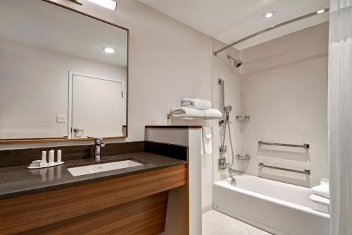 a bathroom with a sink and a tub and a mirror at Fairfield Inn & Suites by Marriott Selinsgrove in Selinsgrove