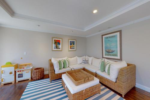 a living room with a white couch and wicker chairs at Cotuit Mannor in Cotuit