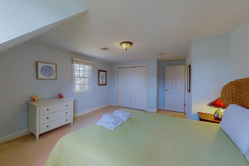 a bedroom with a bed and a dresser and a window at Cotuit Mannor in Cotuit