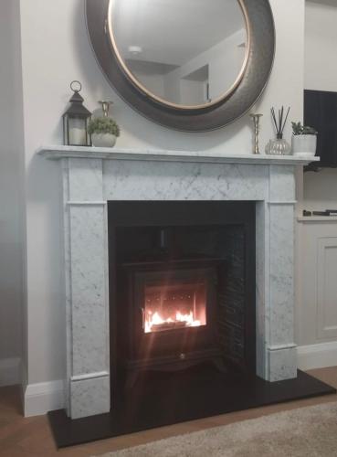 a fireplace with a mirror on top of it at Heather Mere Cottage, Bowness-on-Windermere in Bowness-on-Windermere