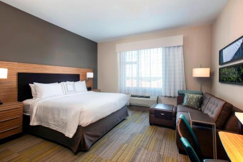 um quarto de hotel com uma cama e um sofá em TownePlace Suites by Marriott Miami Homestead em Homestead