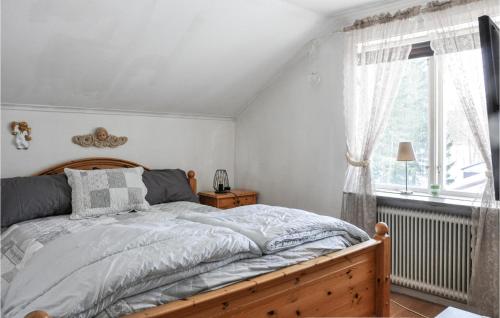 een slaapkamer met een bed en een raam bij Beautiful Home In Koppom With Wifi And 3 Bedrooms in Koppom