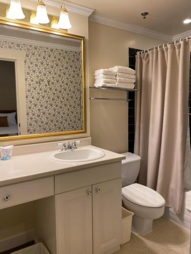 a bathroom with a sink and a toilet and a mirror at Kingston Hotel in Vancouver