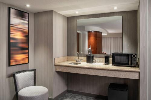 a bathroom with a sink and a microwave at Courtyard by Marriott Edmonton West in Edmonton