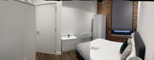 a white bathroom with a bed and a sink at Luxury one bed apartment in Manchester city center in Manchester