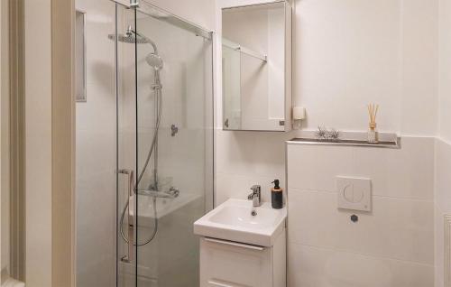 ein weißes Bad mit einer Dusche und einem Waschbecken in der Unterkunft Gorgeous Home In Sunnemo With Kitchen in Sunnemo