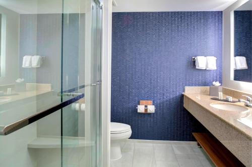 a bathroom with a toilet and a glass shower at Fairfield Inn & Suites by Marriott Virginia Beach Oceanfront in Virginia Beach