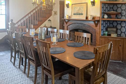 a wooden dining room table with chairs and a fireplace at Clear Skies in Holderness