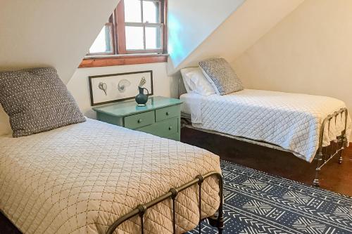 a attic bedroom with two beds and a green dresser at Clear Skies in Holderness