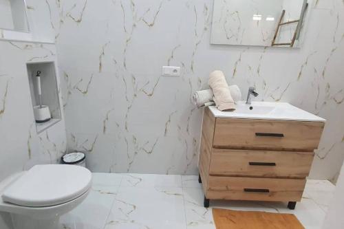 biała łazienka z toaletą i umywalką w obiekcie Paradis w mieście Ngaparou