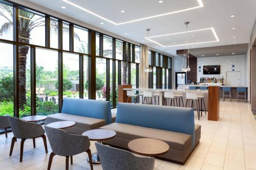 a lobby with a couch and tables and a bar at Residence Inn by Marriott Orlando at Millenia in Orlando