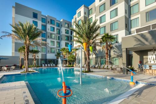 a swimming pool with a fountain in front of a building at Residence Inn by Marriott Orlando at Millenia in Orlando