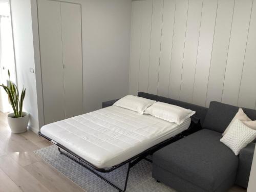 uma cama e um sofá num quarto em In the Heart of Port Melbourne em Melbourne