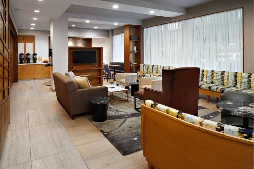 a lobby with couches and chairs and a television at TownePlace Suites by Marriott New York Manhattan/Times Square in New York