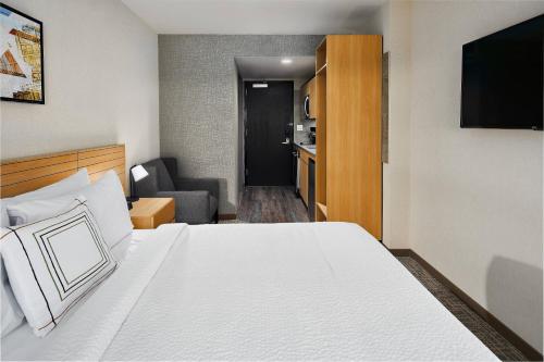 a hotel room with a bed and a living room at TownePlace Suites by Marriott New York Manhattan/Times Square in New York