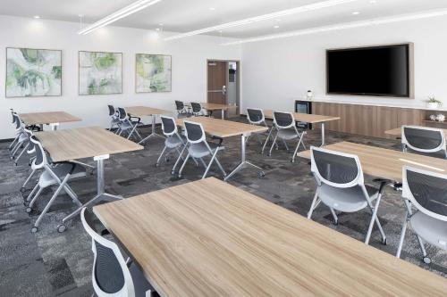 a classroom with tables and chairs and a flat screen tv at Element Bloomington Mall of America in Bloomington