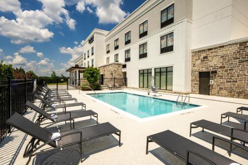 a building with a swimming pool and lounge chairs at Fairfield by Marriott Inn & Suites Rome in Rome