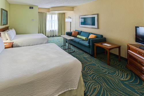 a hotel room with two beds and a couch at SpringHill Suites by Marriott Orlando North-Sanford in Sanford