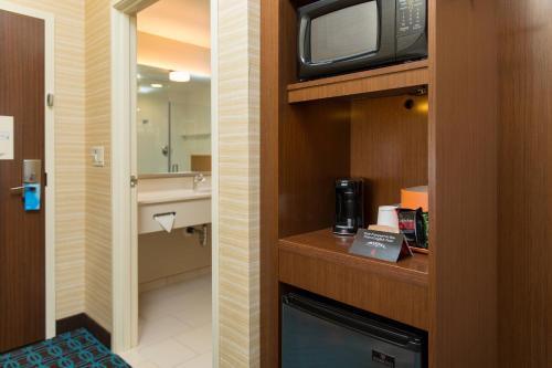 a bathroom with a microwave and a tv on a counter at Fairfield Inn & Suites by Marriott Sacramento Folsom in Folsom