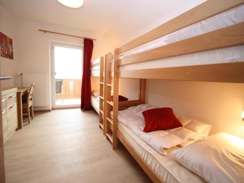 a bedroom with two bunk beds and a desk at Alpensteinbock Mauterndorf II in Mauterndorf