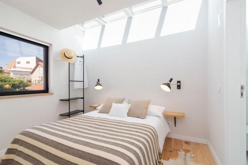 a bedroom with a bed with a large window at Casa da Zanjas in Seia