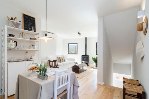 a white living room with a table and a couch at Casa da Zanjas in Seia