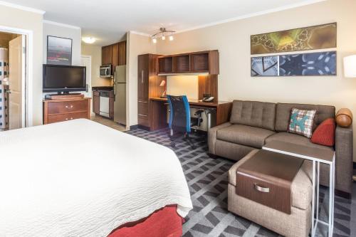 a hotel room with a bed and a couch and a kitchen at TownePlace Suites Tucson Airport in Tucson