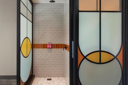 uma casa de banho com um chuveiro e uma porta de vidro em Moxy NYC Lower East Side em Nova Iorque